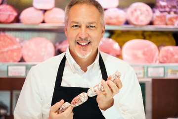 Man showing a salami in a grocery store © Minerva Studio