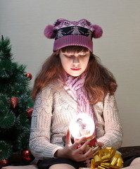 Happy little girl holding a snow globe.
