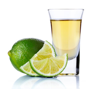 Gold tequila shot with lime isolated on white