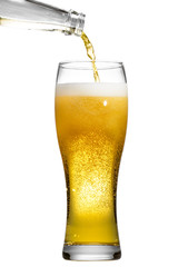 Beer is pouring into glass on white background