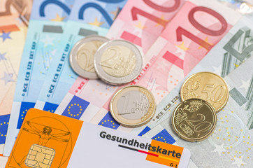 Gesundheitskarte mit Geldscheinen und Münzen