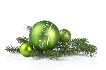 green christmas balls with fir branch isolated on white