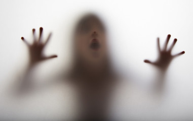 a girl  silhouette behind a  transparent  paper