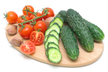tomatoes and cucumbers on the cutting board on a white backgroun