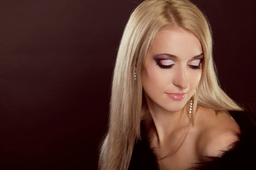 Beautiful woman with blond hair and evening make-up. Jewelry and