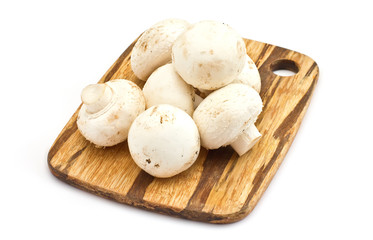 Fresh mushrooms on wooden board isolated on white