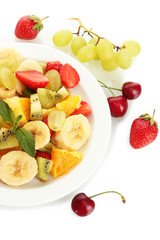 Fresh fruits salad on plate and berries isolated on white