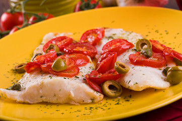 Fish with cherry tomatoes and olive.