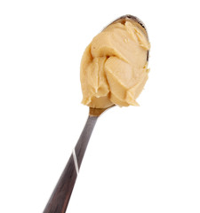 Delicious peanut butter in spoon isolated on white close-up