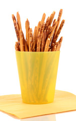 Tasty crispy sticks in yellow plastic cup isolated on white