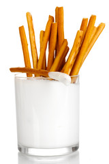 Tasty crispy sticks in glass with sour cream isolated on white