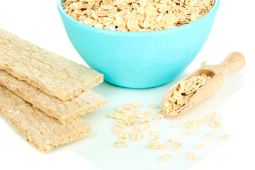 Blue bowl full of oat flakes with wooden scoop and oat biscuits