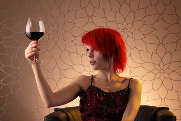 Eine Frau hebt prüfend ein Glas Rotwein