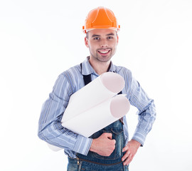 Male architect looking at blueprints against white background