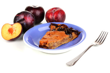 Tasty pie on blue plate with plums isolated on white