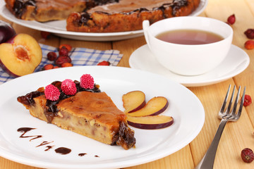 Tasty pie on plate on wooden table