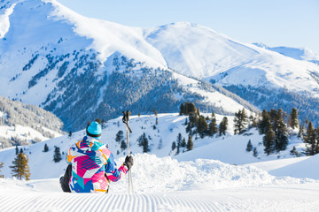 Man sitting on top of Alps, resting after skiing