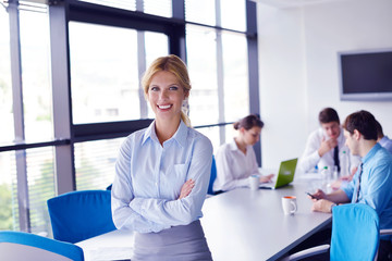 business woman with her staff in background at office