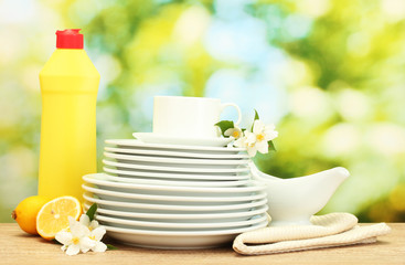 empty clean plates and cups with dishwashing liquid, flowers