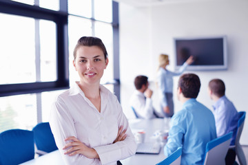 business woman with her staff in background at office