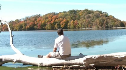 Man Staring at Fall Colors at Lake