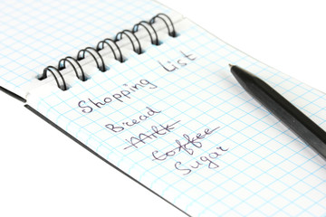 shopping list in a notebook on white background close-up