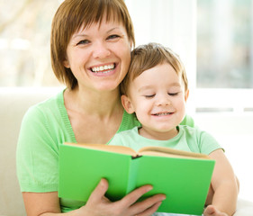 Mother is reading book for her son