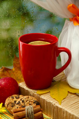 cup of hot tea and autumn leaves, on rain background