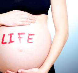 Pregnant woman with the word LIFE on her tummy