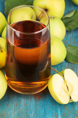 Useful apple juice with apples around on wooden table