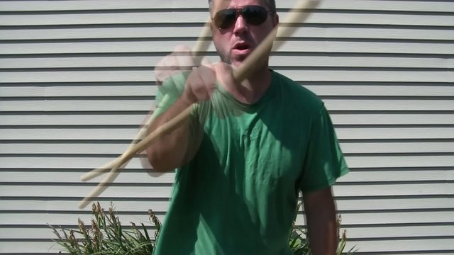 Man Swinging Stick at Camera
