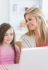 Fototapeta na wymiar Matka uśmiecha się do córki za pomocą laptopa