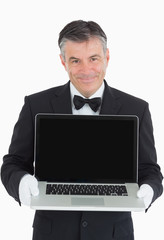 Smiling waiter showing us something on a laptop