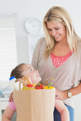 Obraz na płótnie Canvas Mała dziewczynka patrząc na matkę po zakupy spożywcze