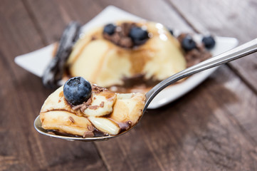 Vanilla Pudding with sauce on a spoon