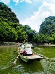 woman climbing boat taking tourists to visit, trangan, ninhbinh,