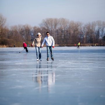 Couple Ice Skating Outdoors On A Pond On A Lovely Sunny Winter D