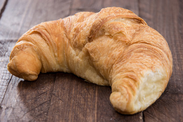 Croissant on wooden background