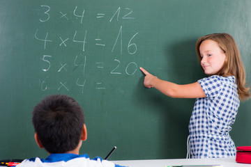 sch&uuml;lerin zeigt etwas an der tafel