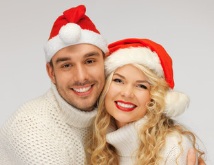 family couple in sweaters and santa's hats