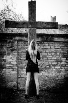 ragazza prega sotto il crocifisso