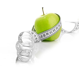 Measuring tape wrapped around a green apple