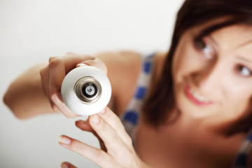 Young woman changing a light bulb