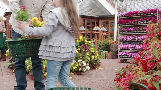 Little girl choosing plant and putting it in basket - Powered by Adobe