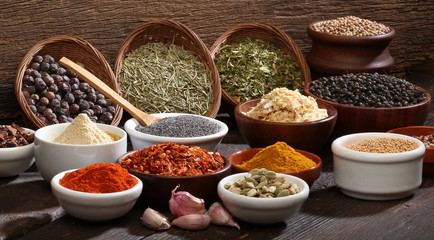 Various bowls of spices over wooden background.