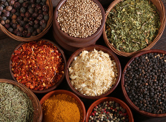 Different bowls of spices over a wooden background