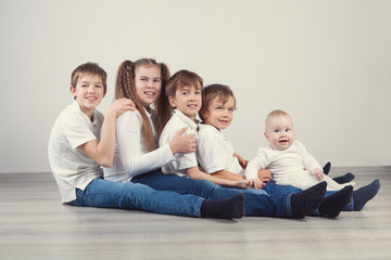 Group of kids in jeans sitting on floor