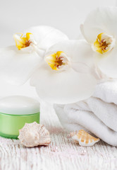 Obraz na płótnie Canvas Moisturizing cream with orchids and towel