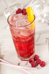 Red drink with raspberries and ice