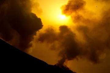 Selbstklebende Fototapete Vulkan Rauchender Vulkan bei Sonnenuntergang